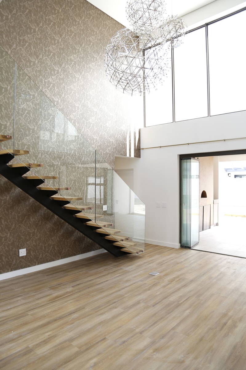floating-staircase-with-glass-railing-stacking-doors-to-patio